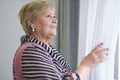 Shot of a happy senior woman smiling looking away Portrait of Elegant mature lady looking out of window. Royalty Free Stock Photo