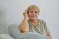 Shot of a happy senior woman smiling looking away Portrait of Elegant mature lady sitting on the couch at home Royalty Free Stock Photo