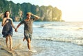 Getting our dose of vitamin sea. Shot of a happy young couple holding hands while running along the beach. Royalty Free Stock Photo