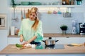 Healthy young woman cutting fresh vegetables while cooking healthy food in casserole in the kitchen at home Royalty Free Stock Photo