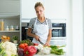 Healthy young woman cutting fresh vegetables in the kitchen at home. Royalty Free Stock Photo