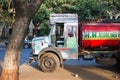 Shot of an Indian man sitting in a truck under a tree with the sunlight on him