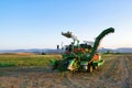 Shot of an industrial tomato picking machine working in the field on a sunny day. Royalty Free Stock Photo