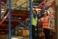 Shot of industrial workers checking inventory and quantity of storage product on shelf in a large warehouse Royalty Free Stock Photo