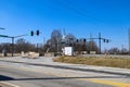 A shot of an intersection near a railroad crossing blocked off with do not enter signs with traffic lights, brown winter trees Royalty Free Stock Photo