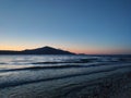 shot of the Ionian Sea from a pebble beach, with a setting sun