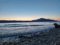 shot of the Ionian Sea from a pebble beach, with a setting sun