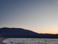 shot of the Ionian Sea from a pebble beach, with a setting sun