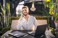 Happy businessman with celphone and laptop sitting at desktop Royalty Free Stock Photo