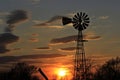 Kansas Windmill Sunset with clouds and a colorful sky with tree`s. Royalty Free Stock Photo