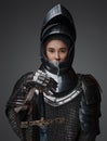 Female knight dressed in steel armor holding sword