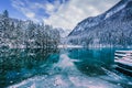 Frozen lake on the Jezersko plateau with blue waters and snow covered woods