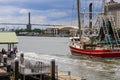 A shot of a large red and white fishing boat sailing on the Savannah River with vast green river water and blue sky with cloud