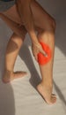 shot of legs in pain, reddened part, hands touching the swollen part, white background