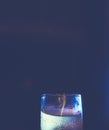 A shot with liqueur with colorful reflections of light of different colors stands on a dark background. Lots of copypace. Hipster-