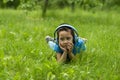 Little boy listening to music with  headphones while lying in a meadow   and dreamily looking into the distance Royalty Free Stock Photo