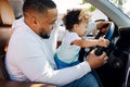 Shot of a little boy sitting on his father`s lap in a car Royalty Free Stock Photo