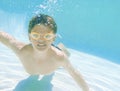 Hes a very good swimmer. Shot of a little boy wearing swimming goggles while swimming underwater. Royalty Free Stock Photo