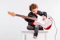 Shot of a little curls boy playing rock music with electric guitar. Royalty Free Stock Photo