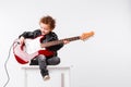 Shot of a little curls boy playing rock music with electric guitar. Royalty Free Stock Photo