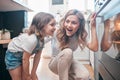 Baking cookies is comforting. Shot of a little girl and her mother sitting in front of the oven. Royalty Free Stock Photo