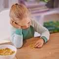 I dont like this cereal. Shot of a little girl looking sad while eating breakfast at home. Royalty Free Stock Photo