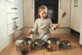 This one goes out to all my fans. Shot of a little girl playing drums on a set of pots in the kitchen. Royalty Free Stock Photo