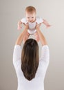 Shot of loving mother lifting baby above head