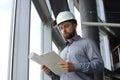 Shot of male architect wearing hardhat and inspecting new building