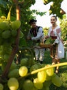 Shot of a male and a female wearing Moldovian traditional clothes at the time of grape harvesting