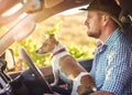 My driveway is its own long dirt road. Shot of a man and his dog driving out in the countryside. Royalty Free Stock Photo
