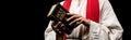 Shot of man holding book with holy bible letters on black