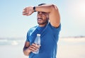 That run was super intense. Shot of a man holding a bottle water while looking exhausted during his run. Royalty Free Stock Photo