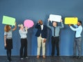 What did I get myself in to. Shot of a man looking overwhelmed as people hold up speech bubbles around him. Royalty Free Stock Photo