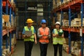 Shot of manager and young workers checking quantity of storage product on shelf and walking through rows of storage Royalty Free Stock Photo