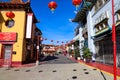 A shot of a market place with colorful buildings with Chinese architecture with several bright red Chinese Tomato Light lanterns