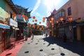 A shot of a market place with colorful buildings with Chinese architecture with several bright red Chinese Tomato Light lanterns