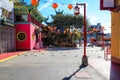 A shot of a market place with colorful buildings with Chinese architecture with several bright red Chinese Tomato Light lanterns