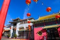 A shot of a market place with colorful buildings with Chinese architecture with several bright red Chinese Tomato Light lanterns