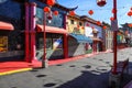 A shot of a market place with colorful buildings with Chinese architecture with several bright red Chinese Tomato Light lanterns