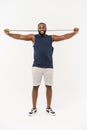 Shot of masculine man skipping rope. Muscular young man exercising with jumping rope against grey background