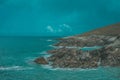 Shot of massive rocks on the shore with turquoise seascape on the background