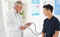 Theres a tool for every test. Shot of a mature doctor monitoring a patients blood pressure at a hospital.