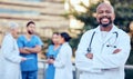 Theres nothing you cant fix with a smile. Shot of a mature male doctor standing with her arms crossed in the city.