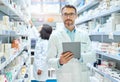 Its a pharmacists best friend. Shot of a mature man using a digital tablet to do inventory in a pharmacy. Royalty Free Stock Photo