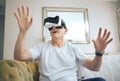 Stepping into another world. Shot of a mature man using a VR headset at home. Royalty Free Stock Photo