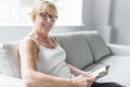 Shot of a mature woman reading her favorite novel while at home in living room. Royalty Free Stock Photo