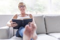 Shot of a mature woman reading her favorite novel while at home in living room. Royalty Free Stock Photo