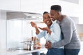 You already know everything you make is delicious. Shot of a man embracing his wife from behind while shes busy cooking.
