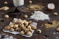 Shot of mini cookies on parchment paper with chocolate bars, flour, eggs, and milk on a table